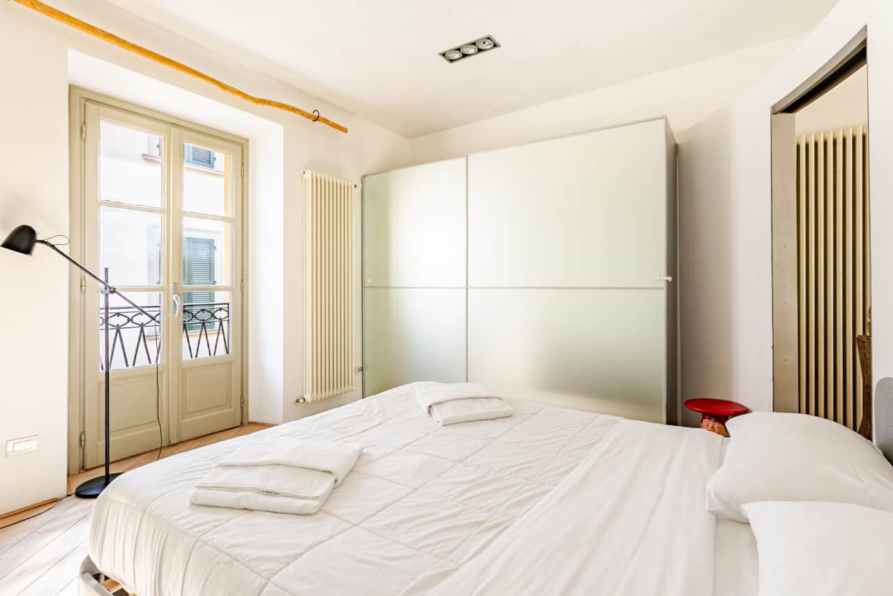 Camera con letto bianco e armadio a tutta altezza