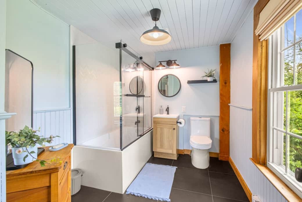 Salle de bain lumineuse tout en lambris, au 2e étage avec bain douche, vue cours