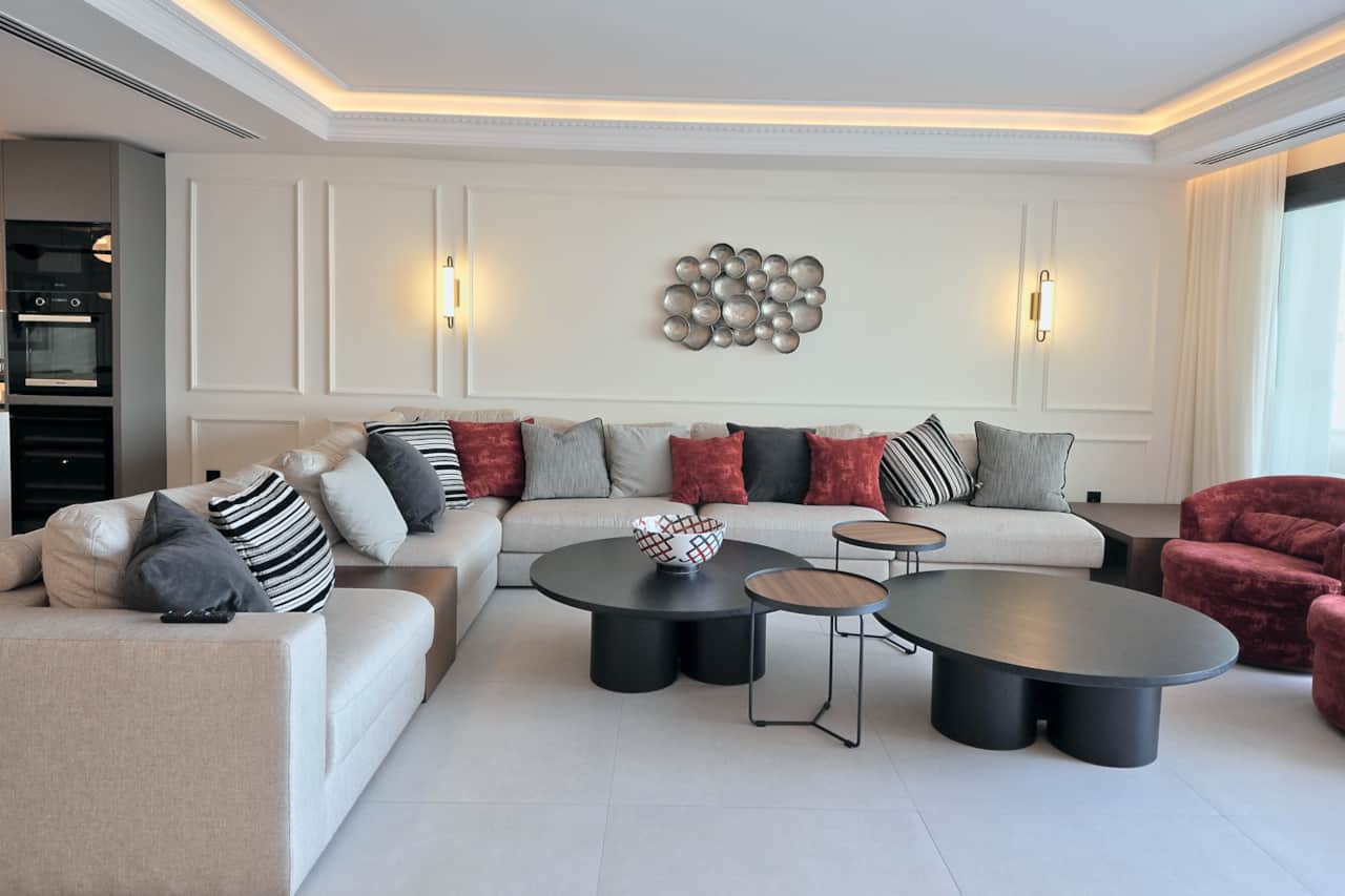 Living room with L-shaped sofa and velvet armchairs