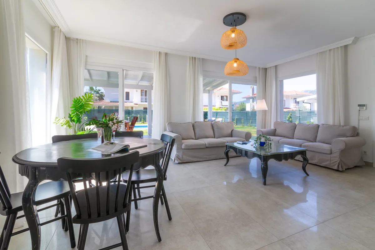 Bright living room with a round dining table, black chairs, and a sofa, Villa Nergis 1, Göcek.
