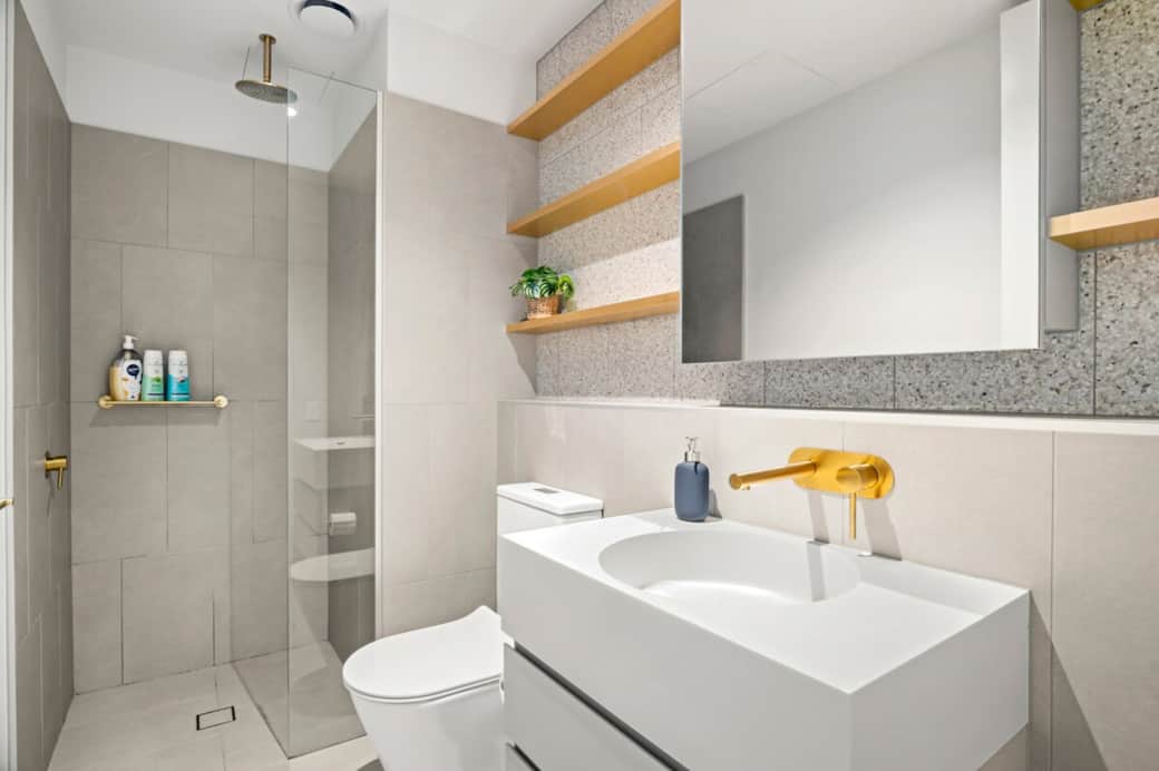 The bathroom features a modern walk-in shower, sleek vanity, and quality fittings, designed for both comfort and convenience. Fresh towels, shampoo, body wash, and essential toiletries are provided for your stay.
