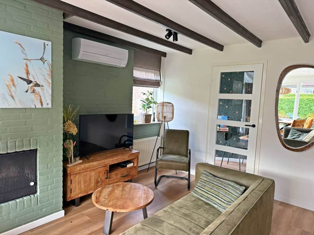 Woonkamer met airco, openhaard, smart televisie (met uitgebreid zenderpakket en Netflix), comfortabele bank, relaxfauteuil en salontafel. Woonkamer met airco, openhaard, smart televisie (met uitgebreid zenderpakket en Netflix), comfortabele bank, relaxfauteuil en salontafel.
