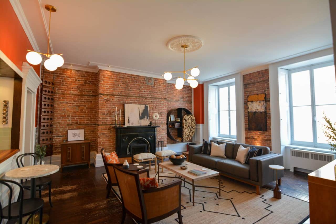 Relax in a stylish living space with exposed brick, original hardwood floors, and cozy décor.