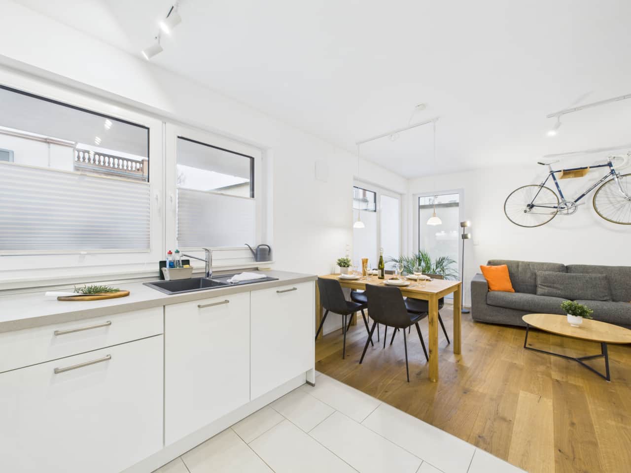Open-plan living and dining area with a modern kitchen, a comfortable sofa bed and a smart TV.