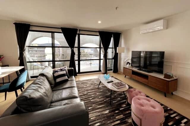 The plush sofa and armchairs provide ample seating, while the large windows offer stunning views and let in plenty of natural light. The balcony is a perfect spot for enjoying your morning coffee or unwinding in the evening.