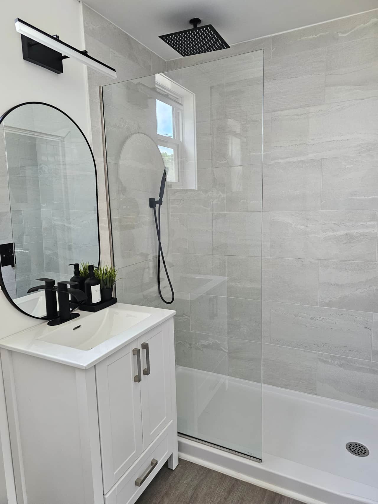 Renovated bathroom featuring a walk-in tiled shower and modern fixtures in a clean and comfortable M