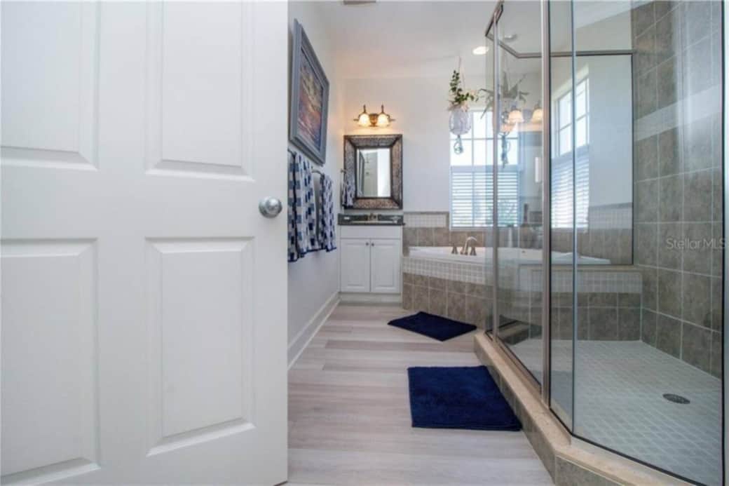 Master bath with two vanities, huge tiled shower with Rainshower showerhead, and soaking tub