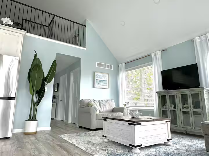 living room with sofa, TV, and views of Lake Huron