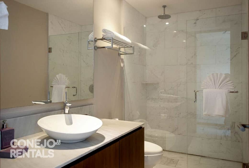 Baño con regadera tipo lluvia y acabados en mármol elegante y fresco en Bolongo Baño con regadera tipo lluvia y acabados en mármol elegante y fresco en Bolongo