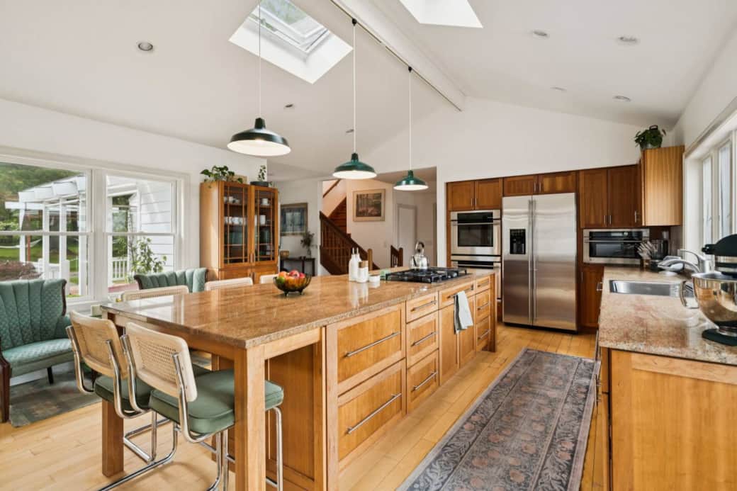 The chef's kitchen features a double oven and gas stove top.