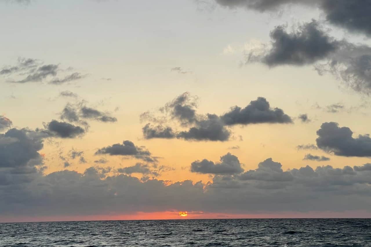 Sunrise view from the beach in front of building.