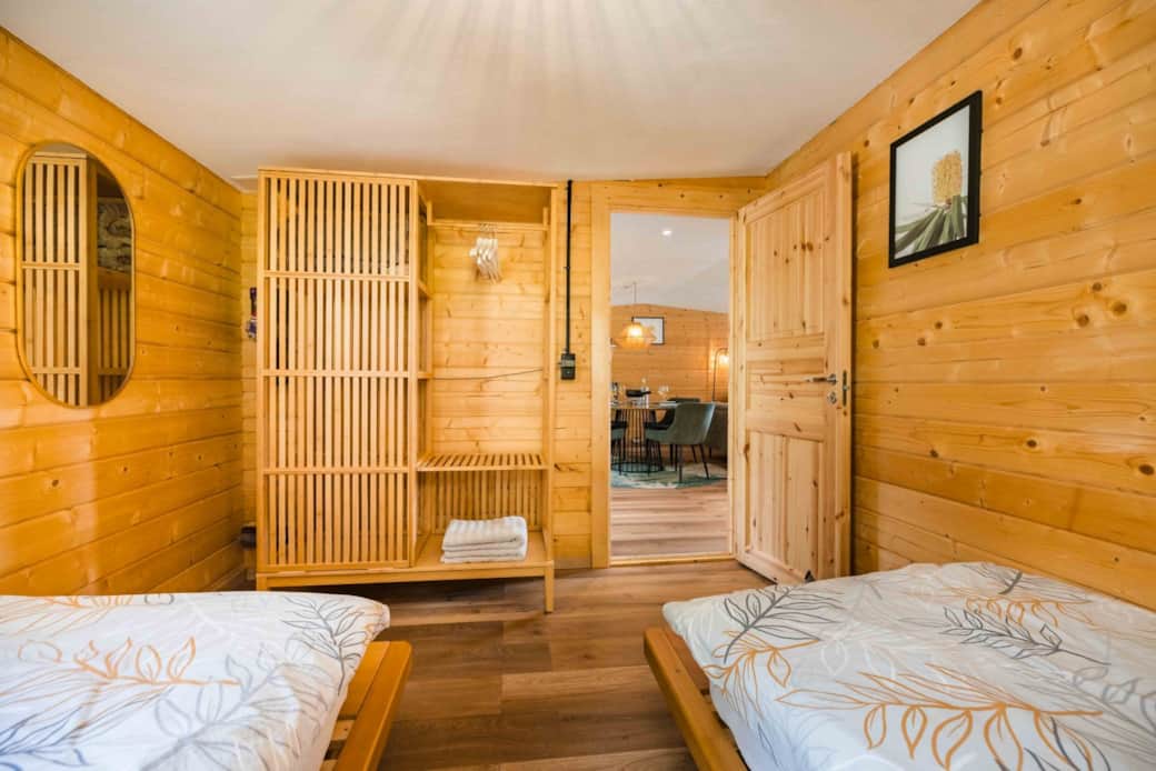 Twin bedroom with wooden interior and open wardrobe at Chalet Oz Twin bedroom with wooden interior and open wardrobe at Chalet Oz