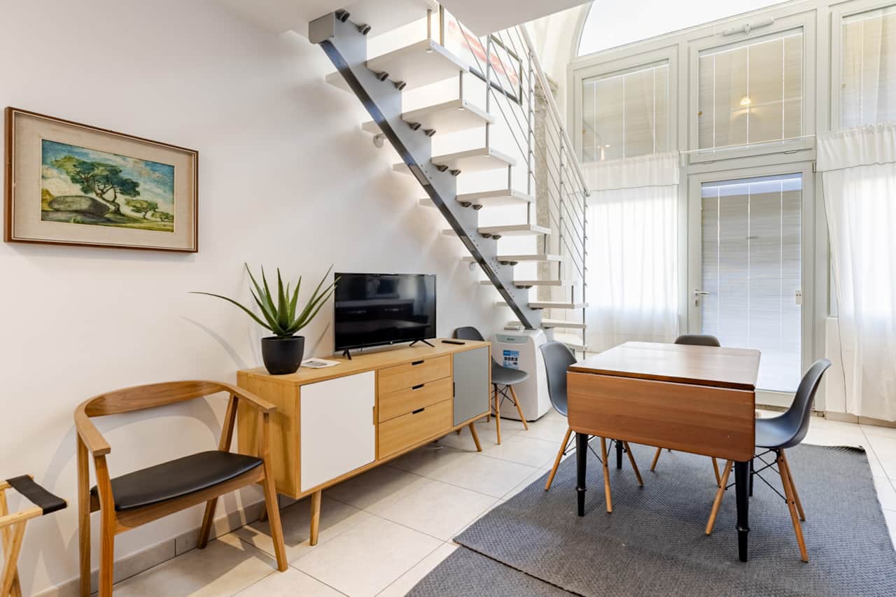 Essbereich mit Tisch, Stühlen und Wendeltreppe aus Metall