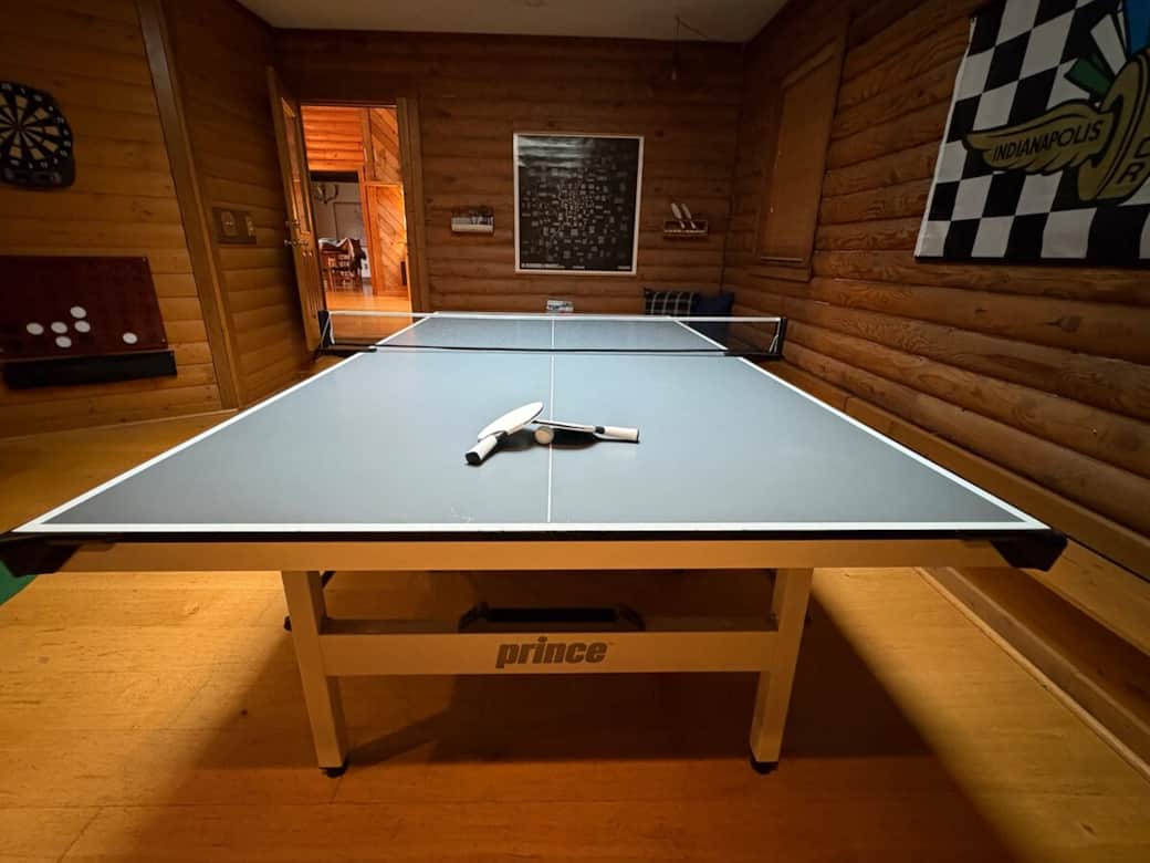 Dedicated game room featuring a full-size ping pong table, darts, games, 65" smart tv, game console, and more!