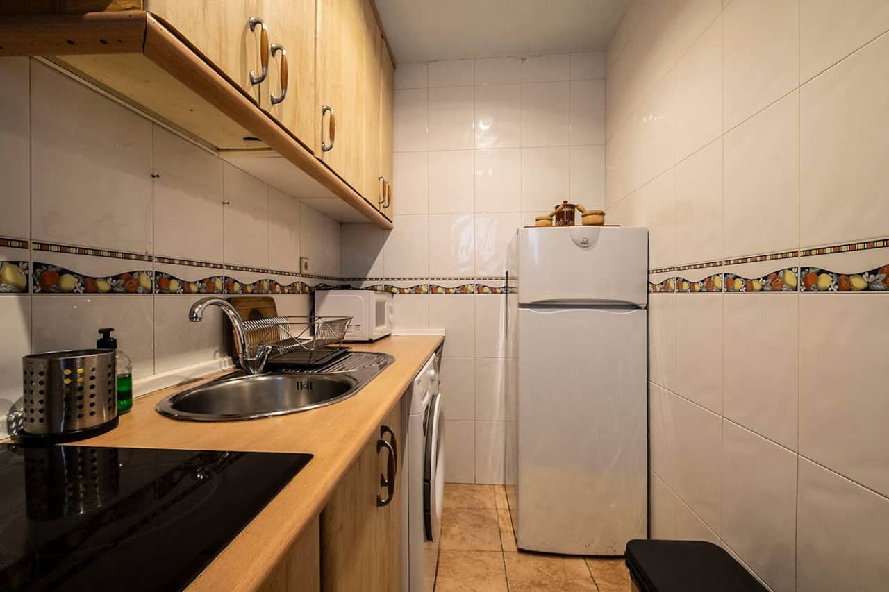 Cocina con nevera grande, fregadero y encimera amplia