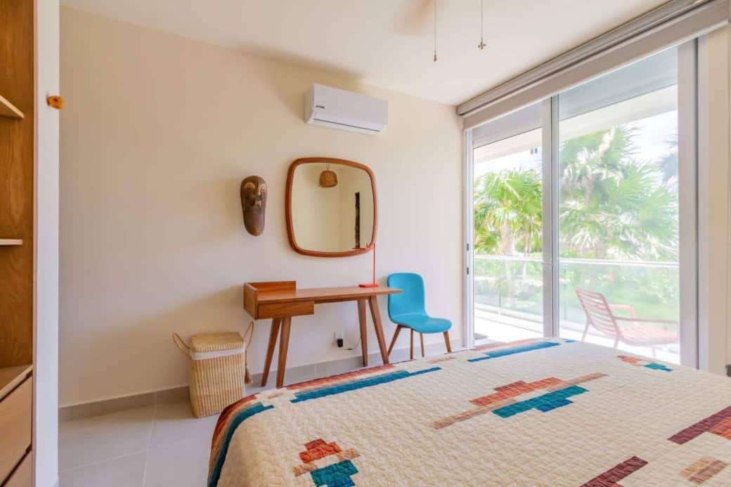 Bright workspace with a sleek table and comfortable chair, perfect for quick tasks. Enjoy air conditioning, room-darkening shades, and direct access to the private terrace with lush tropical scenery and Caribbean Sea views.