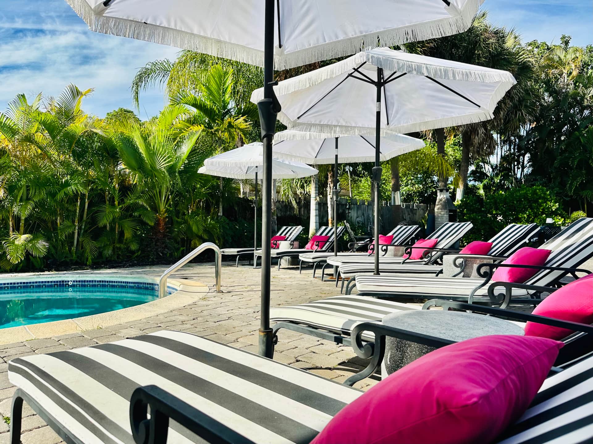 Renovated pool deck at Casa Citron with European style tumbled pavers and lounge seating in Fort Lauderdale