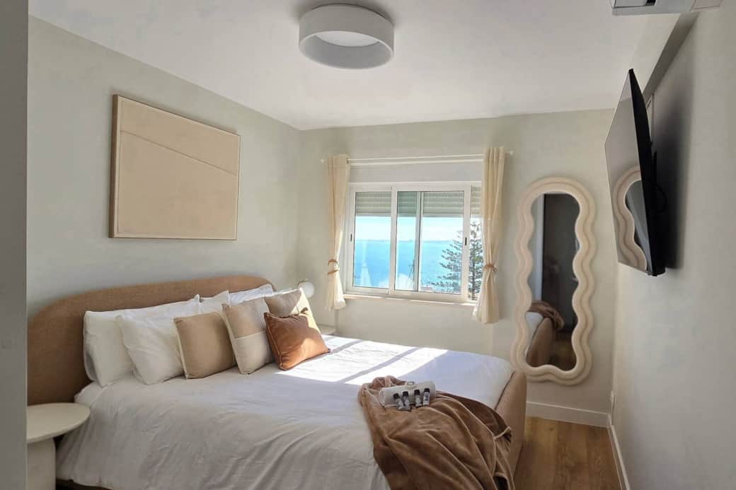 Wake up to this! A view showing the bed, water view, wall-mounted TV, and the all-important AC unit.