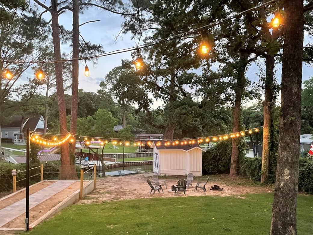 Backyard view with overhead lighting.