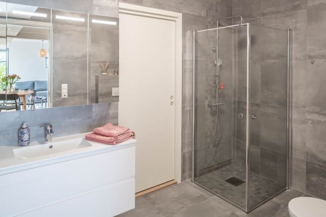 Fully tiled bathroom with a spacious shower. Water-based underfloor heating provides pleasant warmth Fully tiled bathroom with a spacious shower. Water-based underfloor heating provides pleasant warmth