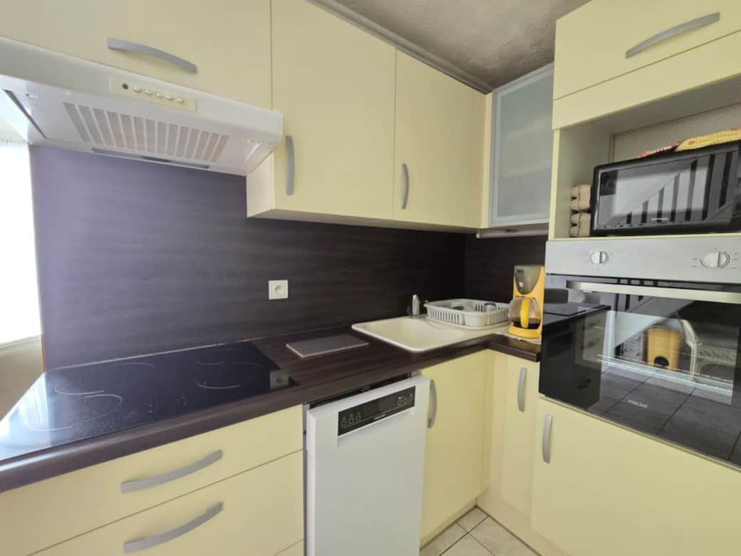 Cuisine équipée avec plaques, micro-ondes et frigo