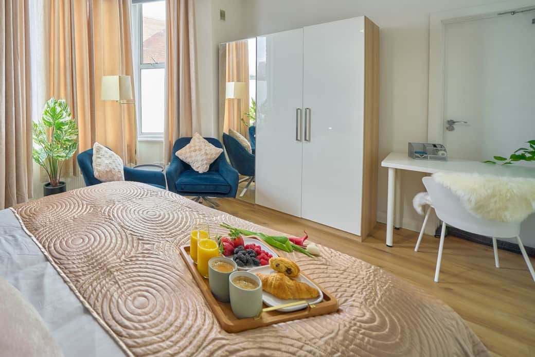 Bright and cosy bedroom with workspace, comfy seating area and plenty of natural light 