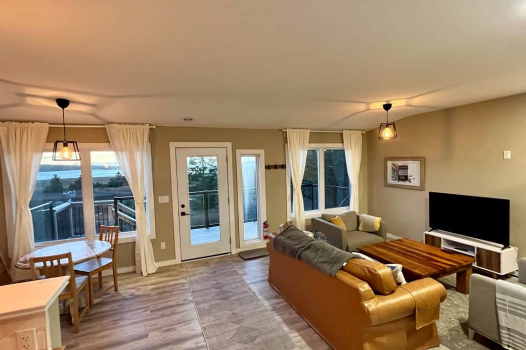 Bright open living with deck views, cozy sectional, and dining nook Bright open living with deck views, cozy sectional, and dining nook