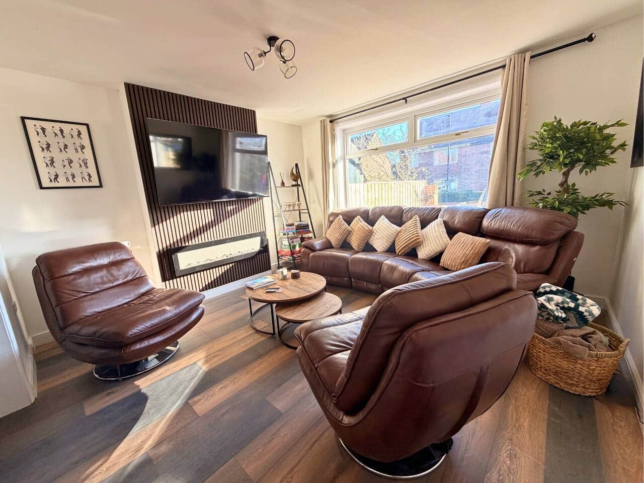 Living room with leather seating, large smart TV and fireplace