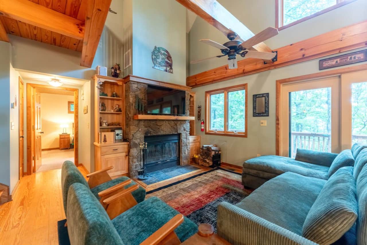 Vaulted living room with a wood-burning fireplace and smart TV — cozy up after a day outside.