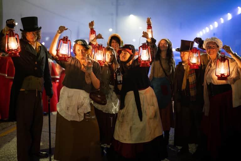 Guests in Victorian costumes posing at Dickens on the Strand in Galveston