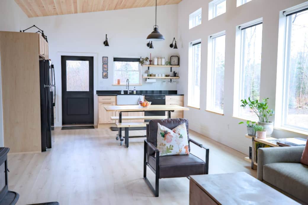 The main living space is filled with natural light. The dining table fits 6.