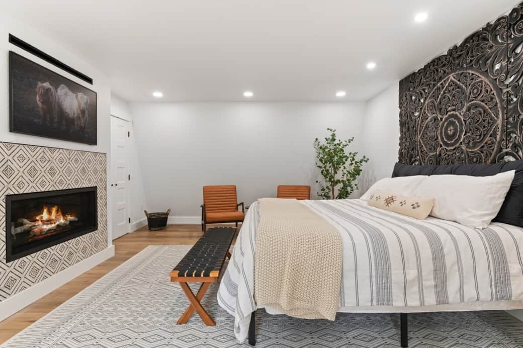 A Zinus 12-inch Green Tea Memory foam mattress/KING bed lets you watch your streaming channels on the 55-inch Samsung Frame TV. Place your luggage at the foot of the bed for easy access. Linear birch gas fireplace for cozy warmth.