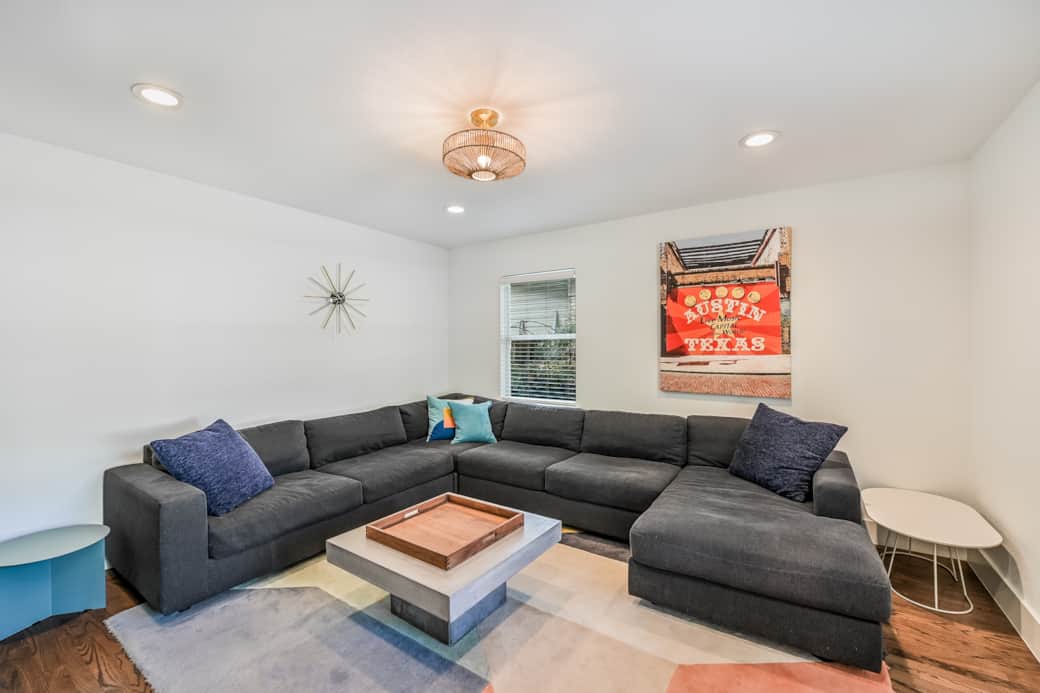 Expansive sectional, vibrant art, and midcentury touches set the stage for your Austin getaway.