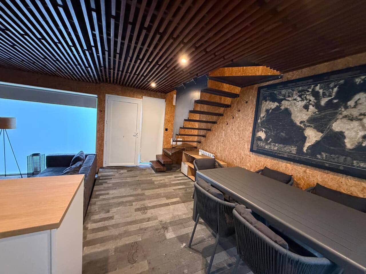 Comedor y escalera al altillo, con mapa decorativo