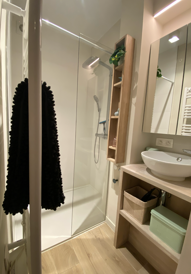 Badkamer met ruime inloopdouche, wastafel, spiegelkast en verwarming