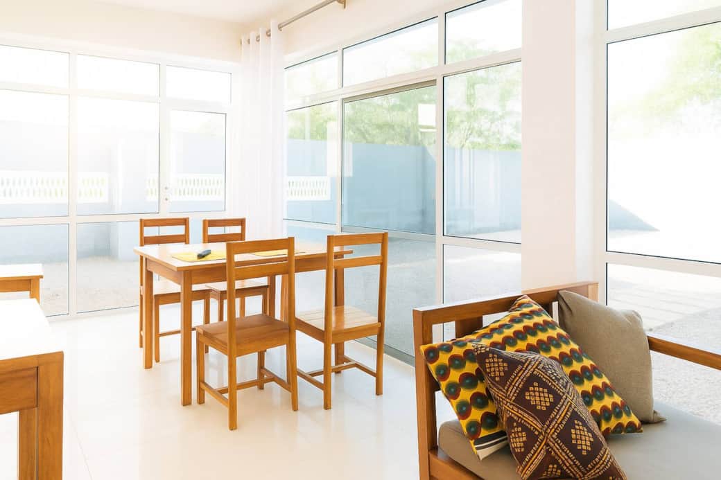 Enjoy meals in this serene, sunlit dining nook. Soft, floor-to-ceiling curtains diffuse natural light across the warm wooden furniture and polished floors, creating an elegant and inviting atmosphere perfect for morning coffee or a cozy dinner. Enjoy meals in this serene, sunlit dining nook. Soft, floor-to-ceiling curtains diffuse natural light across the warm wooden furniture and polished floors, creating an elegant and inviting atmosphere perfect for morning coffee or a cozy dinner.