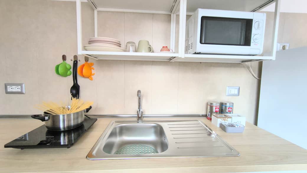 Angolo cottura: lavello, piastra induzione ad 1 fuoco, microonde, stoviglie.
