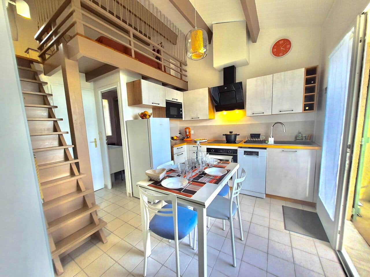 Cuisine entièrement équipée sous une belle hauteur sous plafond avec accès à la mezzanine.