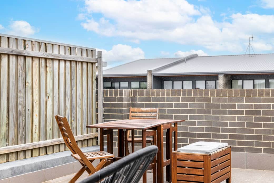Enjoy alfresco dining on our charming patio. The wooden table and chairs are perfect for enjoying meals under the open sky. The brick wall adds a rustic touch, creating a cozy and inviting atmosphere. A delightful spot for whole day activities.