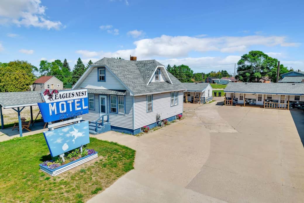 Step into a nostalgic roadside retreat where classic charm meets comfort. This well-kept exterior welcomes you with easy parking, a spacious driveway, and a peaceful setting, making it the perfect starting point for your small-town getaway.