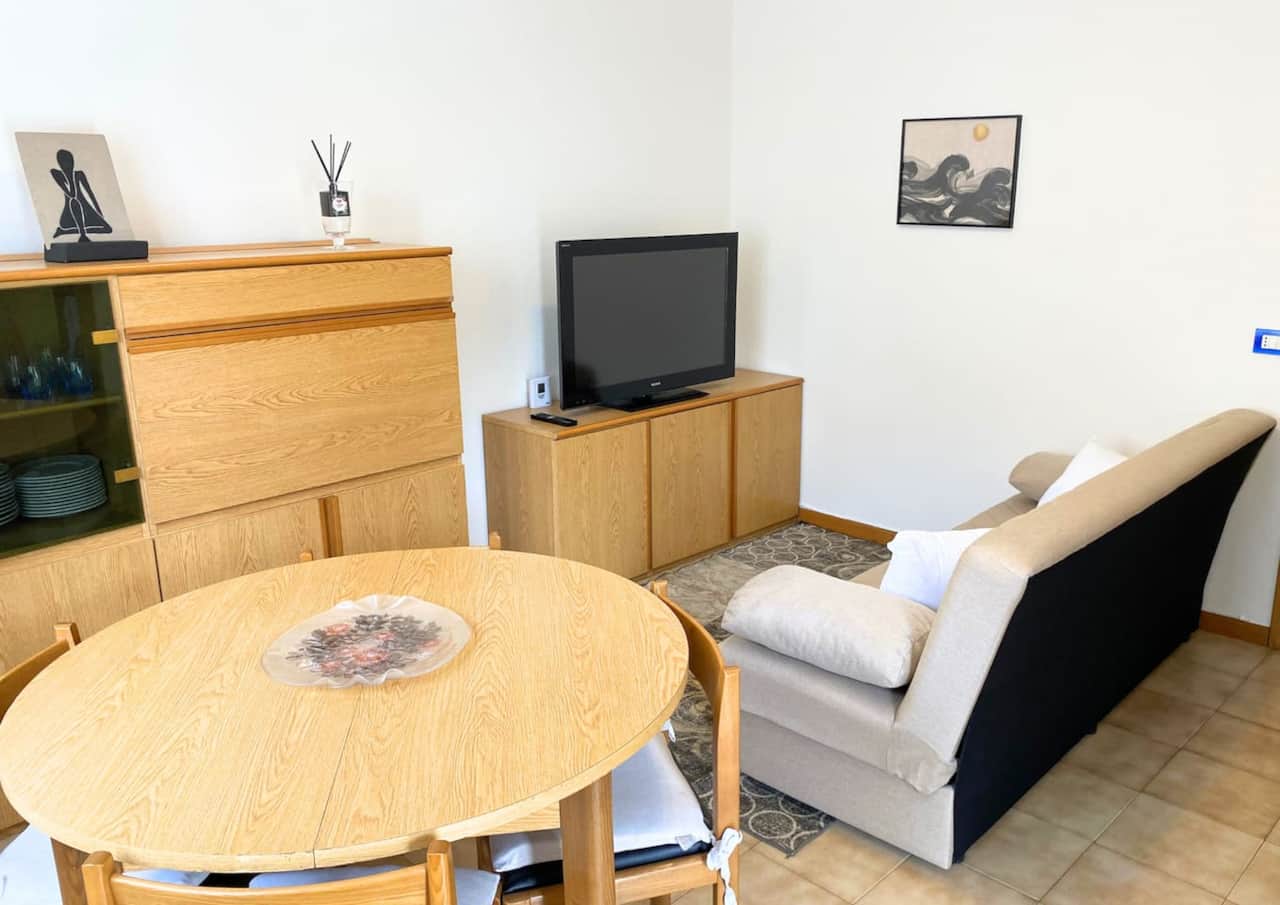 Bellissimo soggiorno dotato di ogni comfort, con divano letto, tv e tavolo da pranzo. Accesso diretto al balcone
