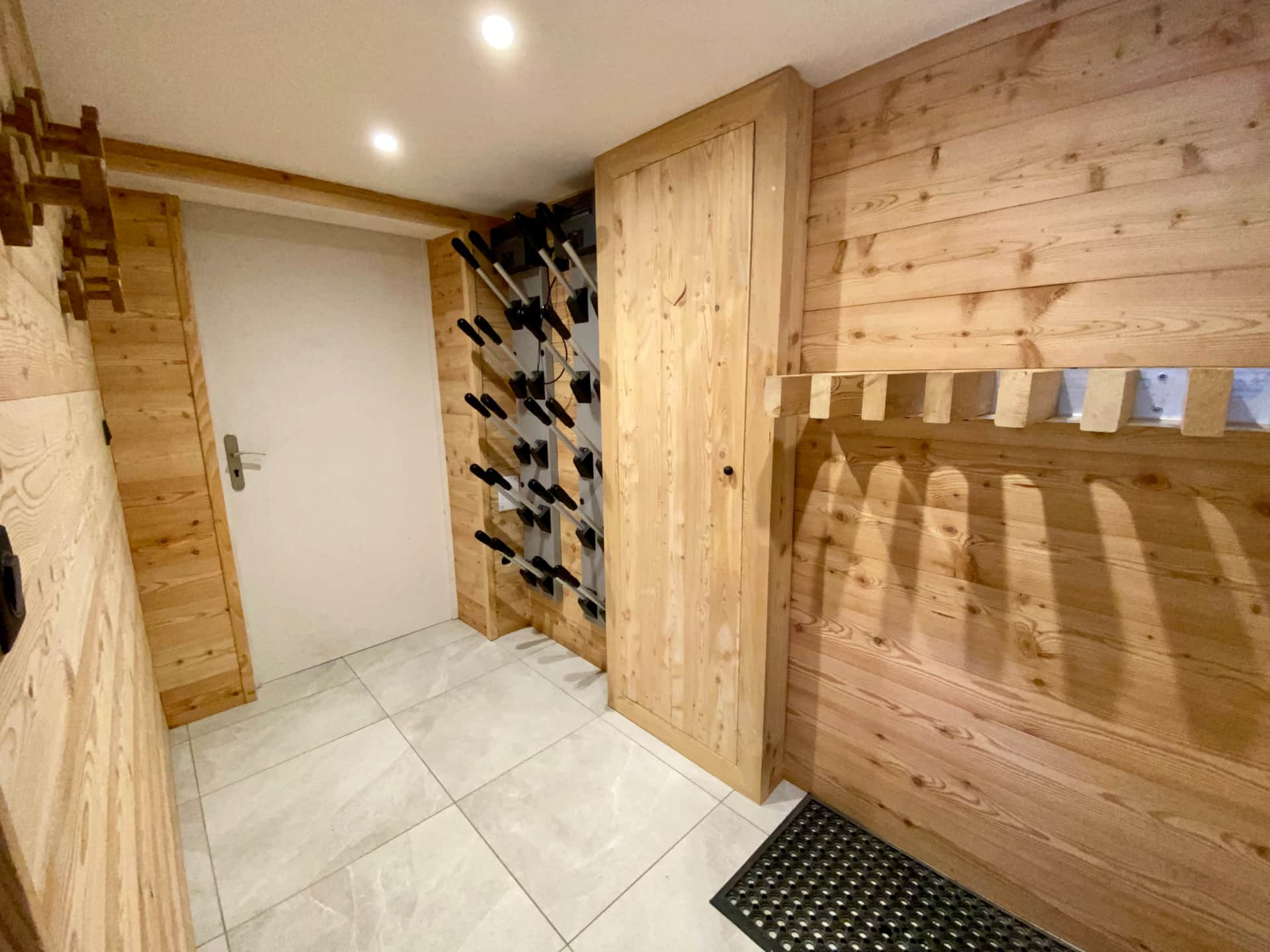 Ski room du Chalet Mont Milo avec sèche-chaussures, rangement skis et équipements, Serre Chevalier Vallée