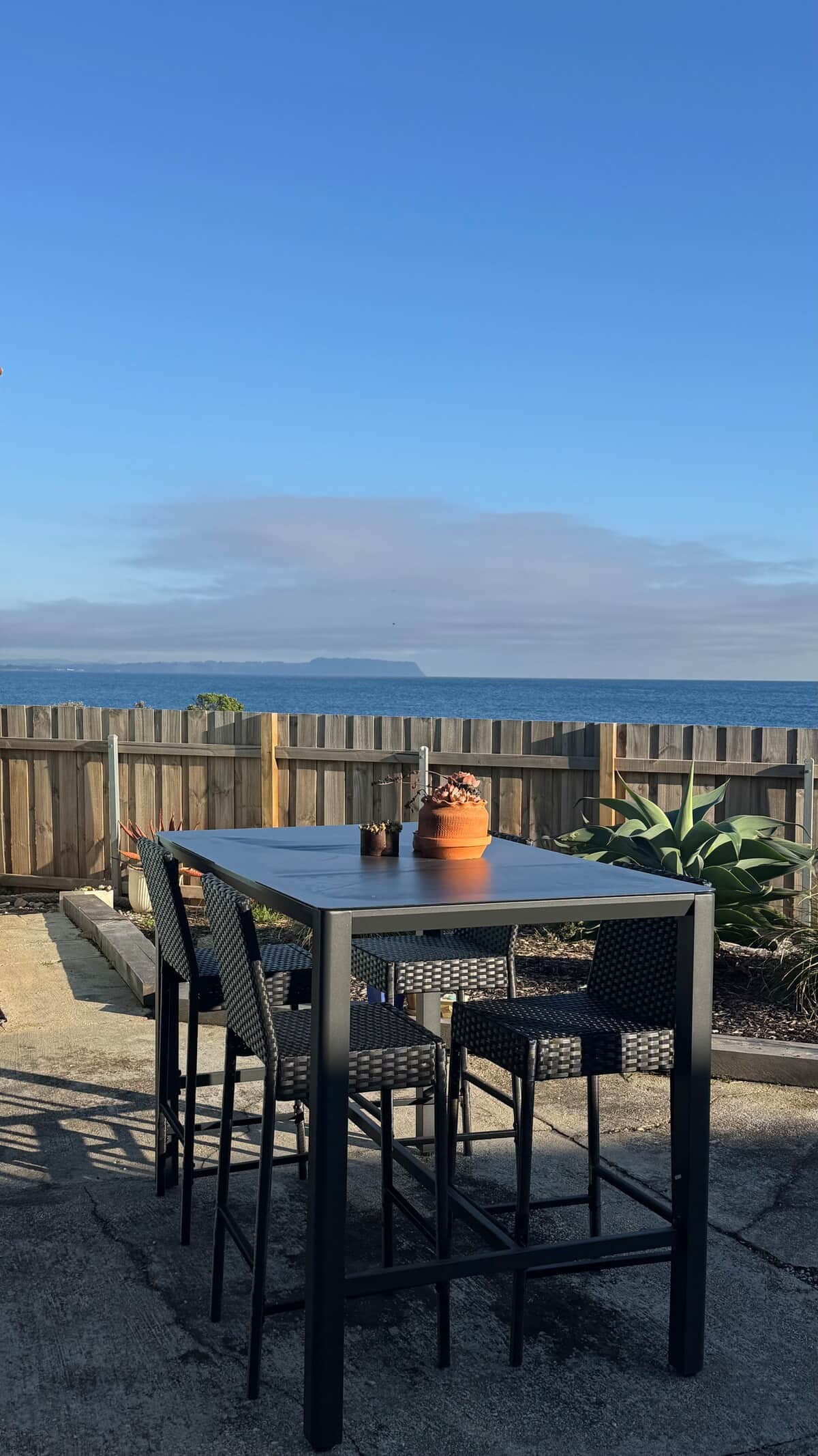 Your backdrop stretches beyond the fence line, where the ocean meets the sky.  It’s the kind of view that invites slow mornings with coffee, long conversations and those quiet, soul‑filling pauses where you simply sit back and take in the horizon.

