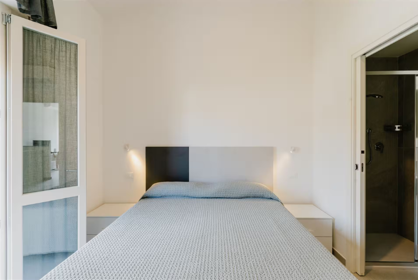 Camera da letto 1 di CasaGiallo Versilia: letto matrimoniale, ambienti luminosi e moderni a Marina di Pietrasanta