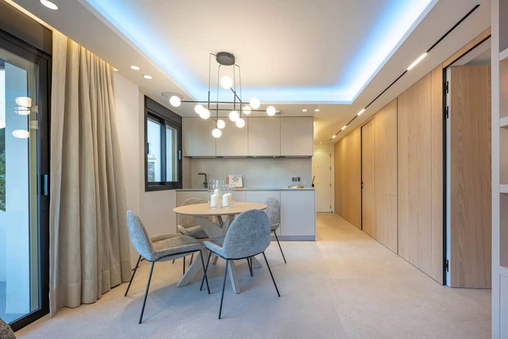 Scan a space that flows with harmony and design. From the dining room to the open-plan kitchen and the wood paneling that hides other rooms, everything connects. Feel the calm of a modern, bright, and perfectly organized home.