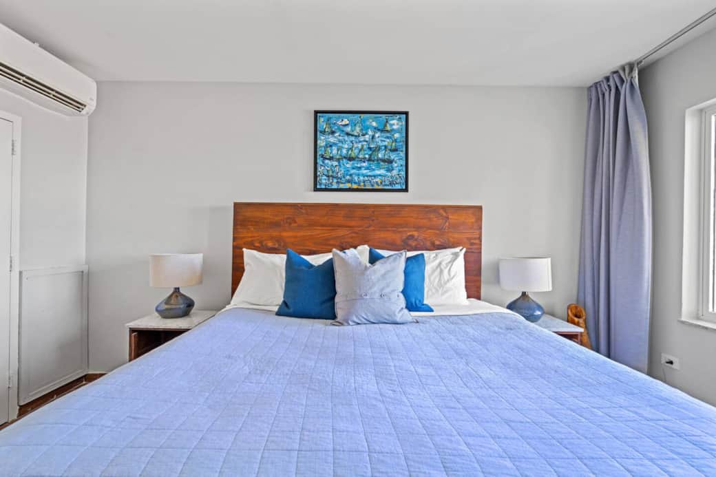 A locally made wooden bed frame with a painting form a local artist
