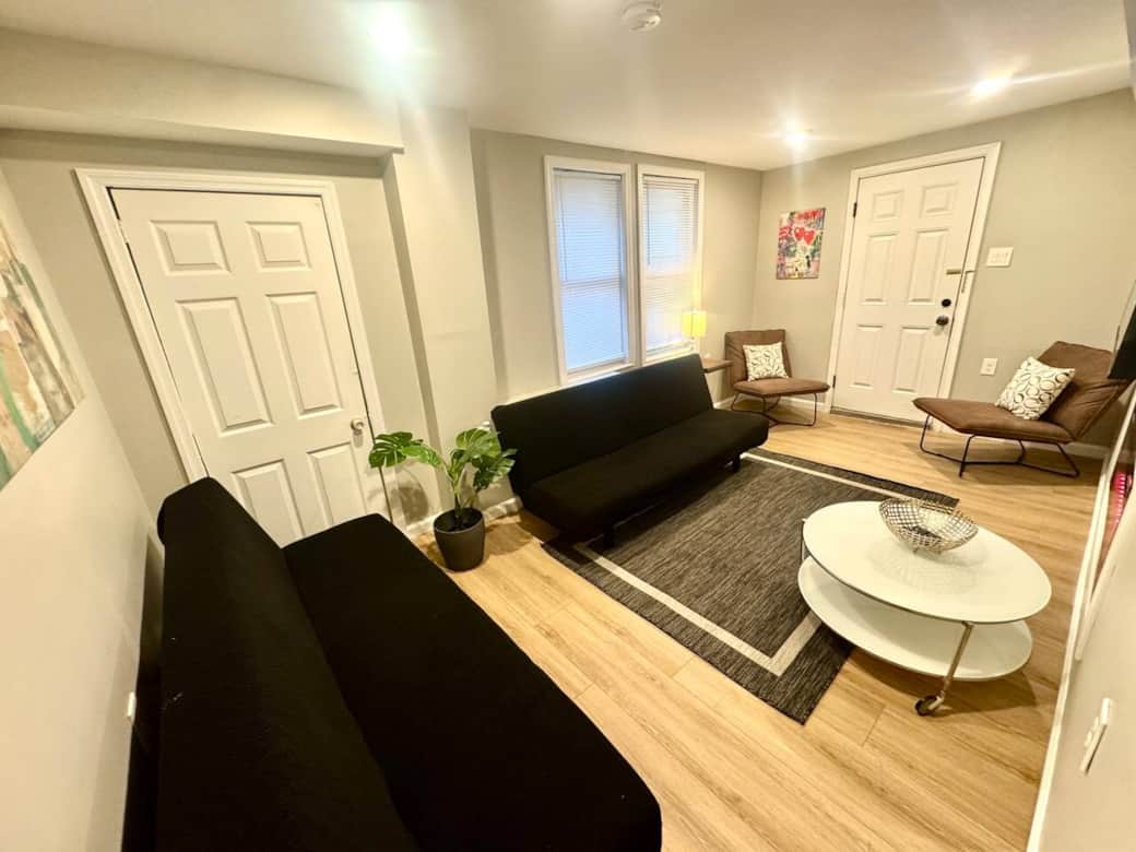 Discover our elegantly designed living room, featuring two versatile futon sofa beds, a large flat-screen television, and a cozy fireplace, providing an ideal setting for both relaxation and social gatherings.