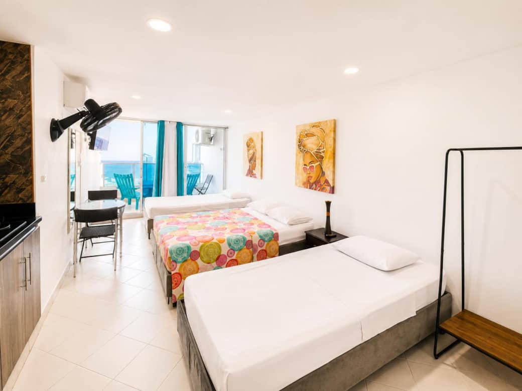 Dos camas sencillas y cama doble, cocina, vista al balcón