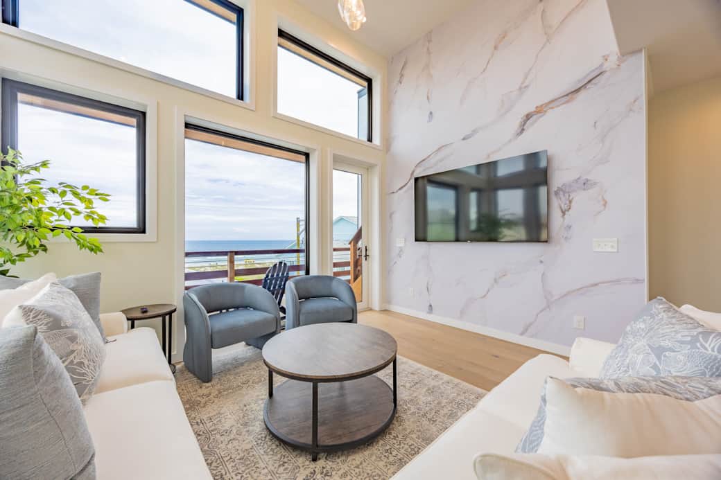 Living room with marble accent wall and TV at Driftwood Carolina