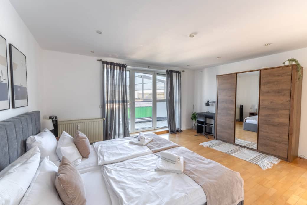 Large bedroom with king-size bed, wardrobe, desk & balcony access